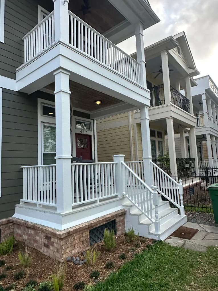 Two-story covered front porch and balcony with custom white railings, built by IAS Boutique Remodeling in Houston, TX.