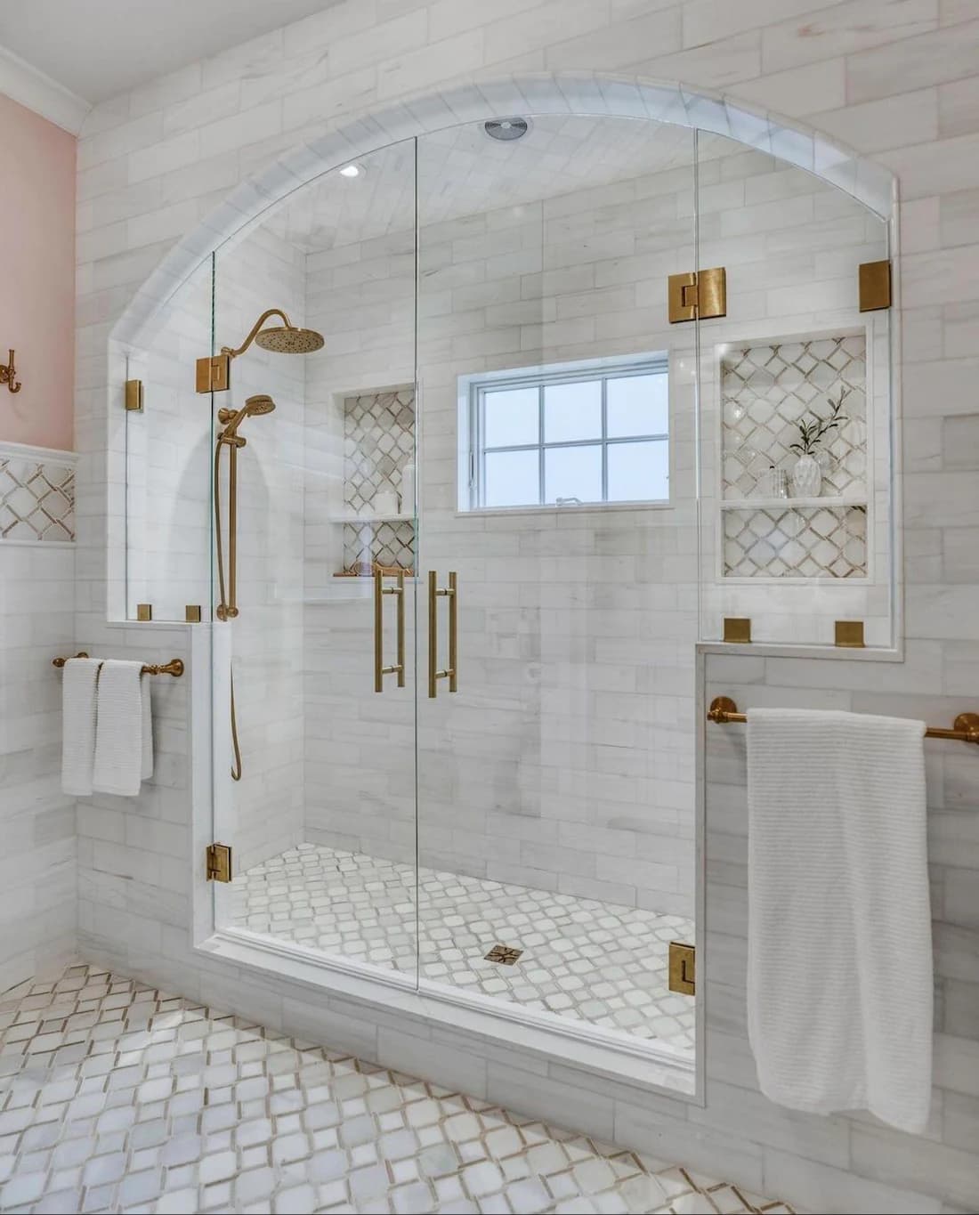 Marble walk-in shower with brushed-gold fixtures in a Houston bathroom remodel by IAS Boutique Remodeling.
